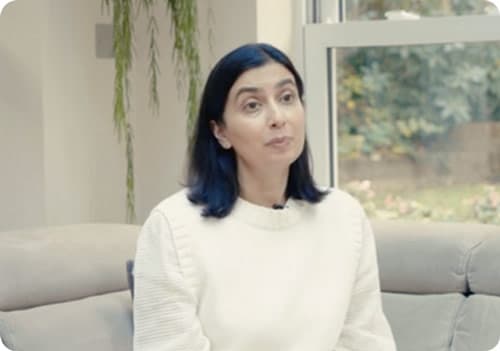 Screenshot of woman in white jumper talking