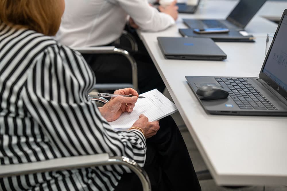 Anne Hutchings taking notes in a Hutchings Pharmacy business meeting