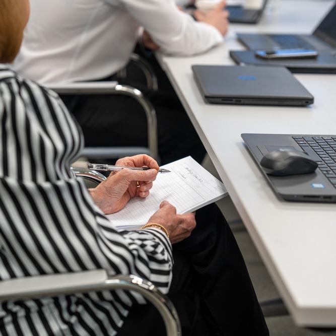 Anne Hutchings taking notes in a Hutchings Pharmacy business meeting