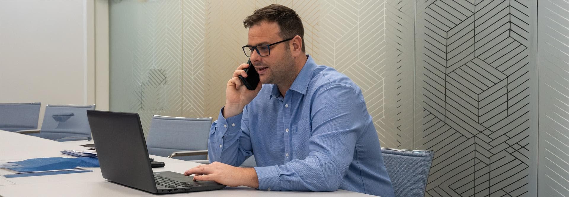Hutchings Pharmacy consultant taking a phone call at his laptop