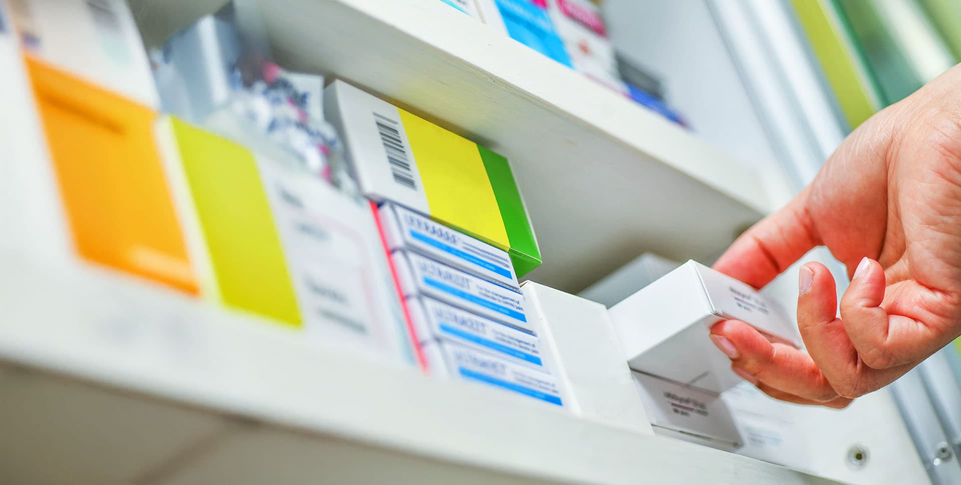 Pharmacist taking medication off of the shelf