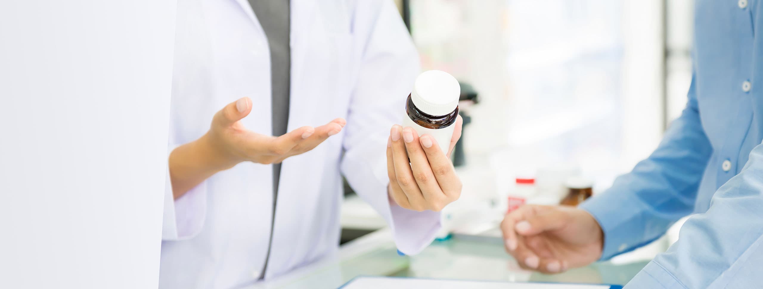 Close up of a pharmacist handing over medication to a customer