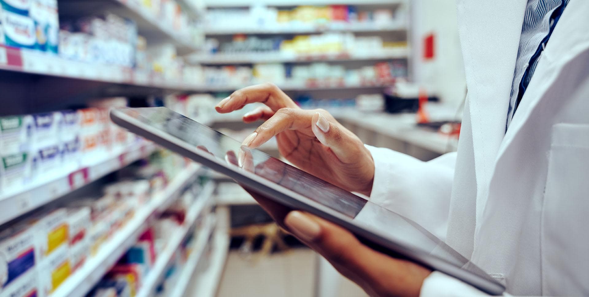 Pharmacist taking stock of medicine on a tablet